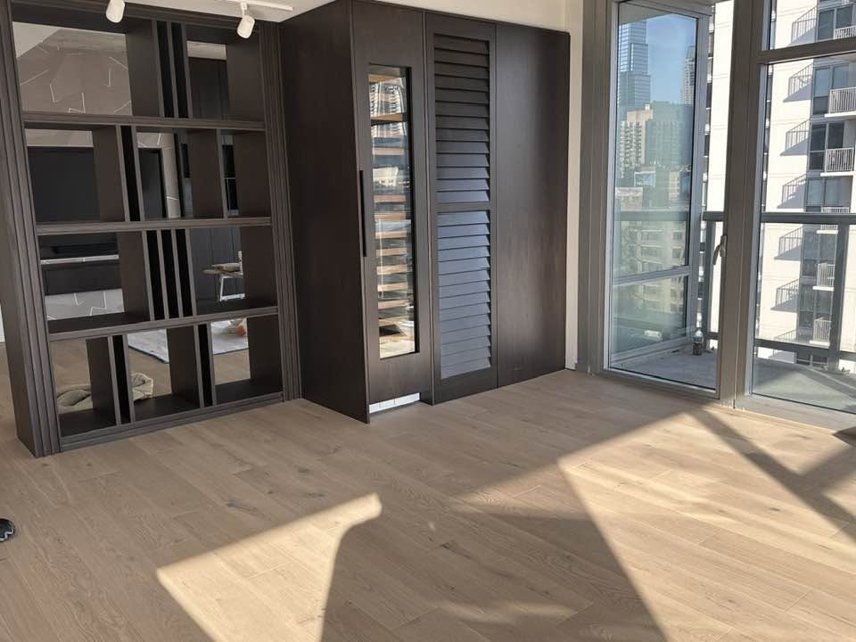 Light hardwood flooring in an open interior with large windows