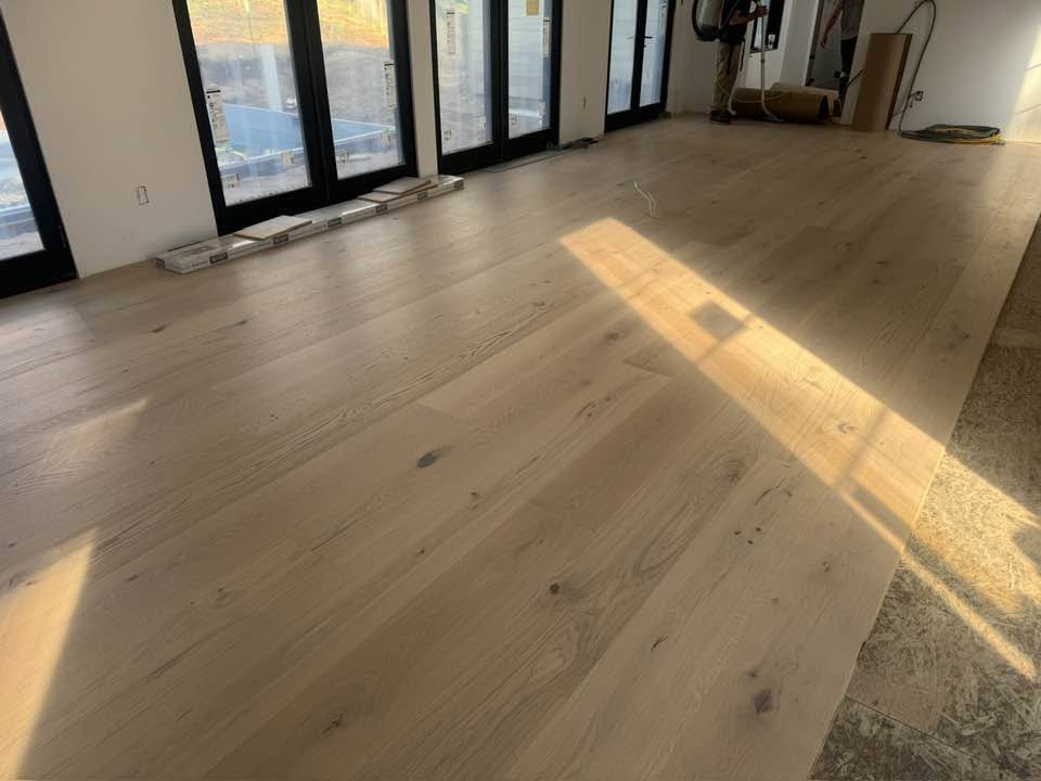 Light hardwood flooring continuing through curved entryways in an MGM Floors project