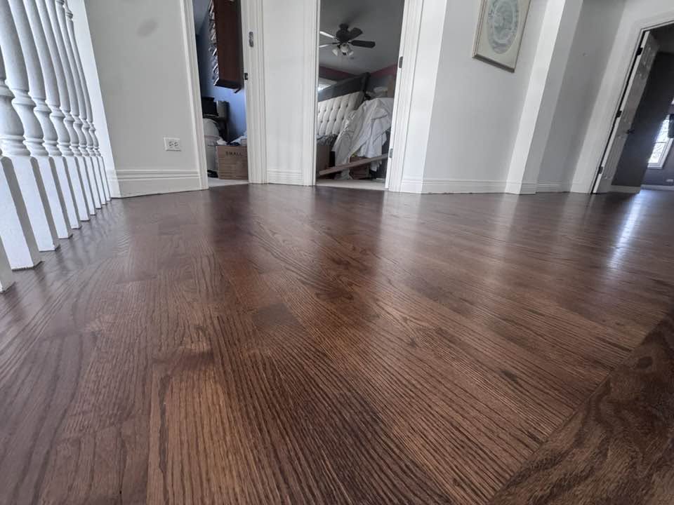 Rich brown hardwood flooring beside white architectural posts in an MGM project