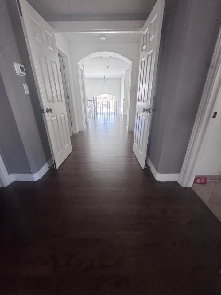 Dark finished hardwood flooring with white posts in an MGM Floors project