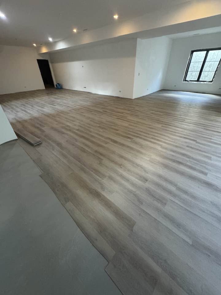 Hardwood flooring running through a bright room with large windows in an MGM project